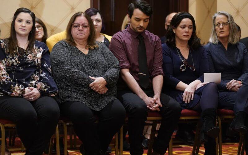 Families of the victims of the Newtown shooting and attorneys listen during a news conference in Trumbull, Conn., Tuesday, Feb. 15, 2022. The families of nine victims of the Sandy Hook Elementary School shooting have agreed to a $73 million settlement of a lawsuit against the maker of the rifle used to kill 20 first graders and six educators in 2012, their attorney said Tuesday. (AP Photo/Seth Wenig)
