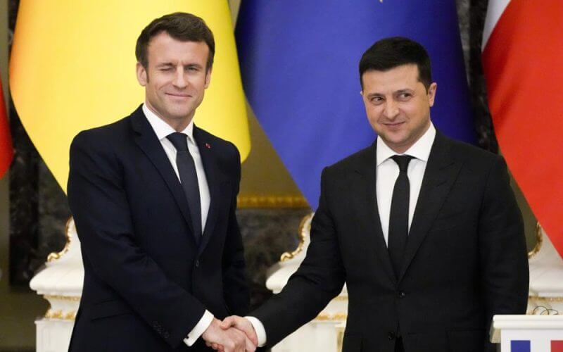 French President Emmanuel Macron, left, winks as he shakes hands with Ukrainian President Volodymyr Zelenskyy after a joint news conference following their talks in Kyiv, Ukraine, Tuesday, Feb. 8, 2022. Diplomatic efforts to defuse the tensions around Ukraine continued on Tuesday with French President Emmanuel Macron arriving in Kyiv the day after hours of talks with the Russian leader in Moscow yielded no apparent breakthroughs. (AP Photo/Efrem Lukatsky)