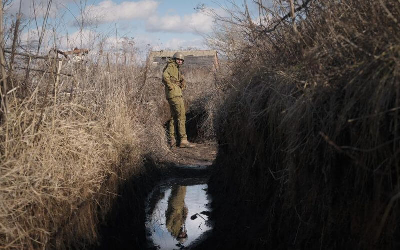 A Ukrainian serviceman pauses while walking to a frontline position outside Popasna, in the Luhansk region, eastern Ukraine, Sunday, Feb. 20, 2022. Russia extended military drills near Ukraine's northern borders Sunday amid increased fears that two days of sustained shelling along the contact line between soldiers and Russia-backed separatists in eastern Ukraine could spark an invasion. Ukraine's president appealed for a cease-fire. (AP Photo/Vadim Ghirda)