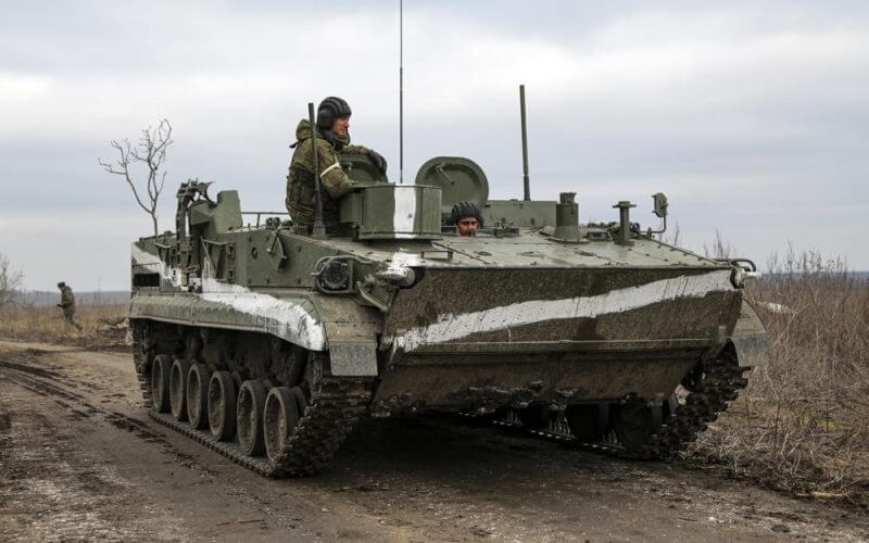 An armored vehicle rolls outside Mykolaivka, Donetsk region, the territory controlled by pro-Russian militants, in eastern Ukraine, Sunday, Feb. 27, 2022. Fighting also raged in two eastern territories controlled by pro-Russia separatists. (AP Photo)