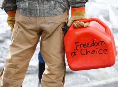 A trucker carries a gas canister with "Freedom of Choice" written on it, as truckers and supporters continue to protest coronavirus disease (COVID-19) vaccine mandates, in Ottawa, Ontario, Canada, February 9, 2022. REUTERS/Lars Hagberg