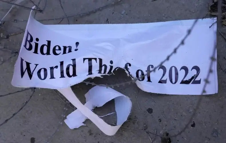 A torn banner lies on the ground after a protest condemning President Joe Biden's decision on frozen Afghan assets, in Kabul, Afghanistan, on February 15, 2022. Biden signed an executive order on February 11 to create a pathway to split $7 billion dollars of Afghan assets frozen in the U.S. to fund humanitarian relief in Afghanistan and to create a trust fund to compensate September 11 victims. AP PHOTO/HUSSEIN MALLA