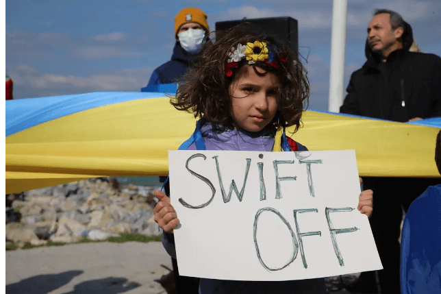 A Ukrainian girl protests the Russian invasion with a sign demanding a Swift ban. Ferdi Uzun/Anadolu Agency via Getty Images