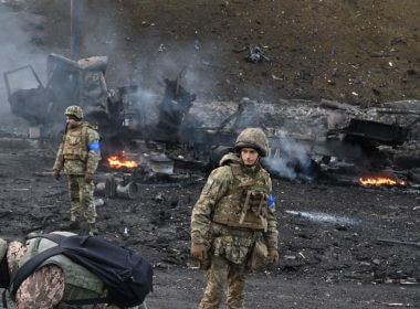 Ukrainian service members look for and collect unexploded shells after fighting with Russian troops in the Ukrainian capital of Kyiv in the morning of February 26, 2022. (Sergei Supinsky/AFP)