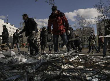 People clear debris outside a medical center damaged after parts of a Russian missile, shot down by Ukrainian air defense, landed on a nearby apartment block, according to authorities, in Kyiv, Ukraine, Thursday, March 17, 2022. Russian forces destroyed a theater in Mariupol where hundreds of people were sheltering Wednesday and rained fire on other cities, Ukrainian authorities said, even as the two sides projected optimism over efforts to negotiate an end to the fighting. (AP Photo/Vadim Ghirda)