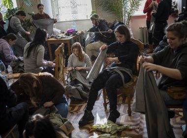 Ukrainian volunteers tear cloth into strips to make camouflage nets in Lviv, western Ukraine, Monday, Feb. 28, 2022. The Russian military assault on Ukraine went into its fifth day after Russian President Vladimir Putin ordered his nuclear forces put on increased alert, ratcheting up tensions yet further. (AP Photo/Bernat Armangue)