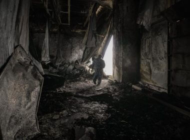 A staff member exits a large food products storage facility which was destroyed by an airstrike in the early morning hours in Brovary, north of Kyiv, Ukraine, Sunday, March 13, 2022. Waves of Russian missiles pounded a military training base close to Ukraine's western border with NATO member Poland, killing 35 people, following Russian threats to target foreign weapon shipments that are helping Ukrainian fighters defend their country against Russia's grinding invasion.(AP Photo/Vadim Ghirda)