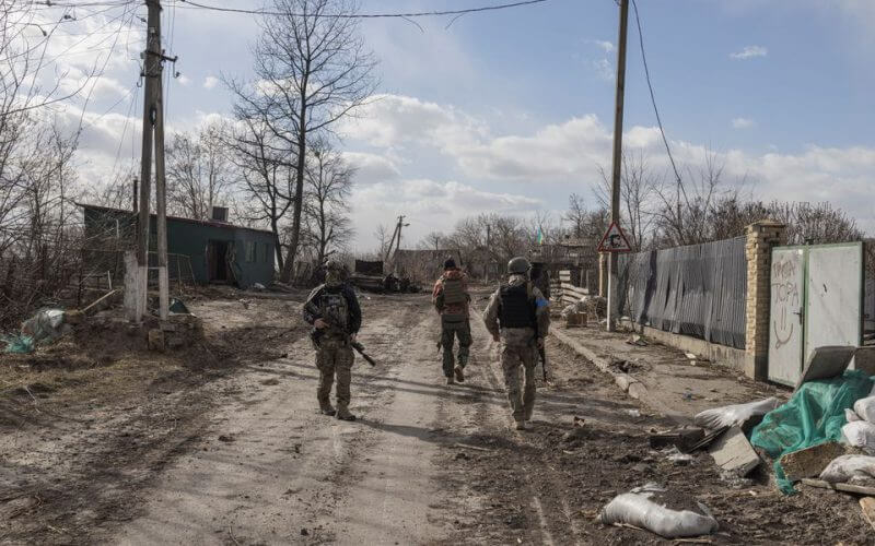 Ukranian servicemen walk through the village of Lukyanivka outside Kyiv, as Russia's invasion of Ukraine continues,
