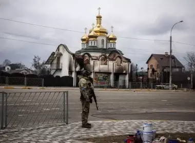 Ukrainian forces have reportedly retaken Irpin, a suburban city near the nation's capital of Kyiv, the city's mayor said in a Facebook video on Monday. Above, a Ukrainian serviceman stands guard on a street in front of a damaged church in Irpin on March 13.