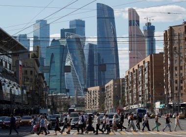Pedestrians cross the road as skyscrapers of the Moscow International Business Center, also known as "Moskva-City", are seen in the background in Moscow, Russia August 10, 2018. REUTERS/Maxim Shemetov
