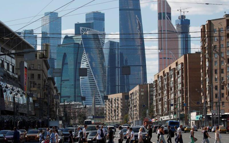 Pedestrians cross the road as skyscrapers of the Moscow International Business Center, also known as "Moskva-City", are seen in the background in Moscow, Russia August 10, 2018. REUTERS/Maxim Shemetov