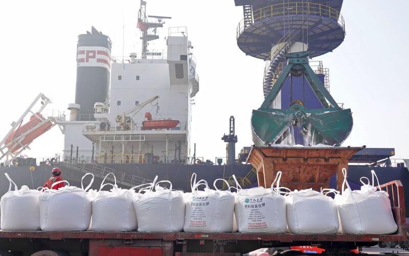 Workers load potassium fertilizer imported from Belarus at a port in China's Shandong province on March 9. Tang Ke/Future Publishing via Getty Images