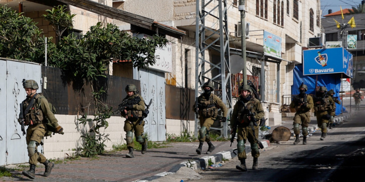 Israeli soldiers run during a raid in Jenin in the Israeli-occupied West Bank March 30, 2022. REUTERS/Mohamad Torokman