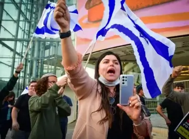 Israelis wave flags as they protest against recent terrorist attacks outside Hakirya Base in Tel Aviv, on March 30, 2022. (photo credit: AVSHALOM SASSONI/FLASH90)