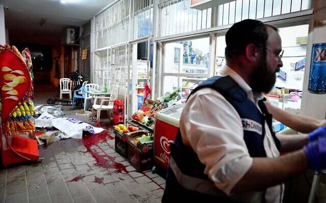 Israeli police officers and medics are seen at the scene of a terrorist shooting attack in Bnei Brak, on March 29, 2022. (Avshalom Sassoni/Flash90)