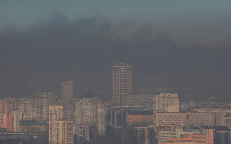 Residential buildings are seen through smoke from fires after shelling on the outskirts of the capital, in Kyiv, Ukraine March 23, 2022. REUTERS/Gleb Garanich