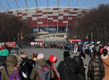 Refugees who fled Ukraine following Russia's invasion on Feb. 24 wait in a long line outside the National Stadium in Warsaw on Saturday to obtain a Polish national identification number. More than 300,000 people fleeing Ukraine have come to Warsaw — causing an almost 20 per cent spike in the city's population of roughly 1.8 million. (Maciek Jazwiecki/Agencja Wyborcza.pl/Reuters)