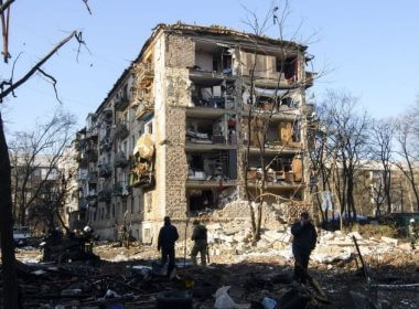 Ukrainian service members stand beside a damaged building in a residential area after shelling in Kyiv, Ukraine, on March 18. Photo by Vladyslav Musiienko/UPI