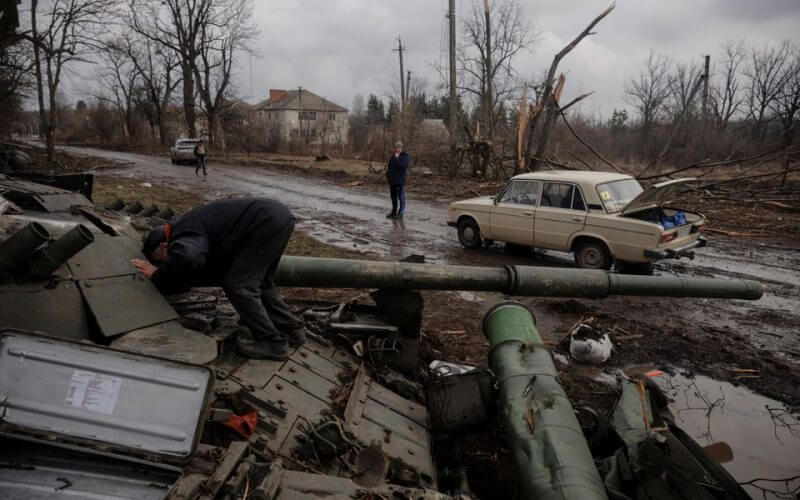 A local man looks into a Russian tank left behind after Ukrainian forces expelled Russian soldiers from the town of Trostyanets which they had occupied at the beginning of its war with Ukraine, March 30, 2022. REUTERS/Thomas Peter