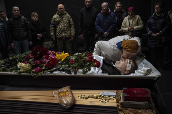 Natalya kisses her brother Sergiy Muravyts'kyi, 61, who was killed by Russian soldiers in the village of Mriya, which means Dream, in Ukrainian, during a ceremony before his cremation in Baikove cemetery, Kyiv, Ukraine, Thursday, March 24, 2022. (AP Photo/Rodrigo Abd)