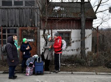 A family wait for transport after fleeing from Ukraine to Romania, following Russia's invasion of Ukraine, at the border crossing in Siret, Romania, March 13, 2022. REUTERS/Clodagh Kilcoyne