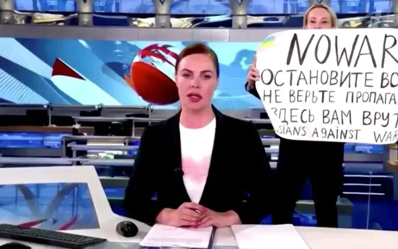 A person interrupts a live news bulletin on Russia's state TV "Channel One" holding up a sign that reads "NO WAR. Stop the war. Don't believe propaganda. They are lying to you here." at an unknown location in Russia March 14, 2022, in this still image obtained from a video uploaded on March 14. Channel One/via REUTERS