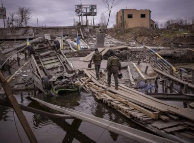 Ukrainian soldiers walk on a destroyed bridge in Irpin, on the outskirts of Kyiv, on Wednesday, April 20, 2022. (AP Photo/Emilio Morenatti)