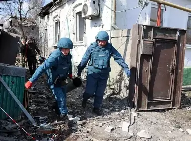 Emergency workers carry a fragment of a missile after shelling in a street in Donetsk, in territory under the government of the Donetsk People’s Republic, in eastern Ukraine, Tuesday, April 5, 2022. (AP Photo/Alexei Alexandrov)