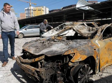 Men inspect destroyed cars in the aftermath of a military strike on a building, amid Russia's invasion, in Odesa, Ukraine, April 24, 2022. REUTERS/Igor Tkachenko