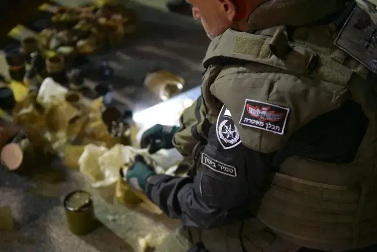 An Israeli police officer inspecting seized explosive devices in northern Israel, on April 25, 2022. Israel Police Spokeswoman