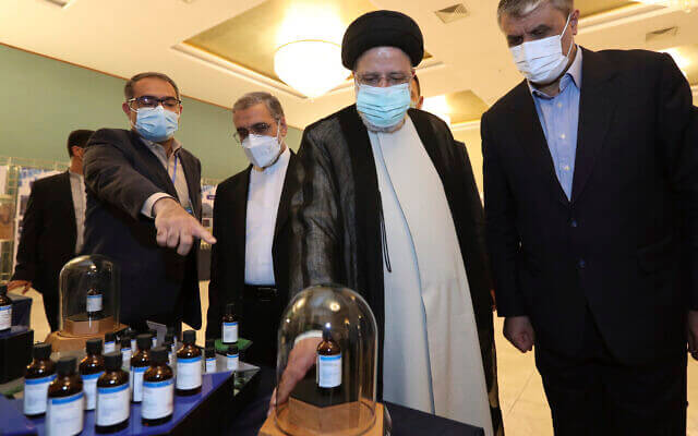 In this photo released by the official website of the office of the Iranian Presidency, President Ebrahim Raisi, second right, receives an explanation while visiting an exhibition of Iran's nuclear achievements in Tehran, Iran, on Saturday, April 9, 2022. (Iranian Presidency Office via AP)