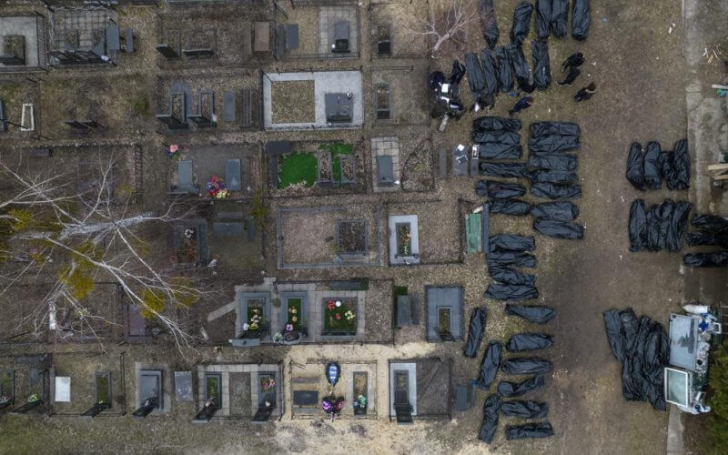Policemen work to identify civilians who were killed during the Russian occupation in Bucha, Ukraine, on the outskirts of Kyiv, before sending the bodies to the morgue, Wednesday, April 6, 2022. (AP Photo/Rodrigo Abd)