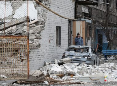 A local resident stands near an apartment building damaged during Ukraine-Russia conflict in the southern port city of Mariupol, Ukraine April 4, 2022. REUTERS/Alexander Ermochenko/File Photo