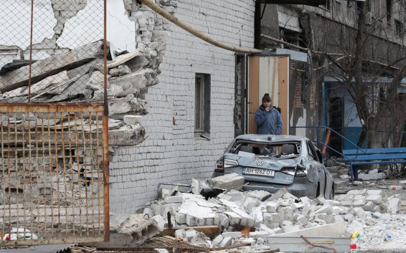 A local resident stands near an apartment building damaged during Ukraine-Russia conflict in the southern port city of Mariupol, Ukraine April 4, 2022. REUTERS/Alexander Ermochenko/File Photo