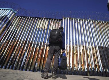 A migrant waits on the Mexican side of the border after United States Customs and Border Protection officers detained a couple of migrants crossing the US-Mexico border on the beach, in Tijuana, Mexico, Jan. 26, 2022. A federal judge in Louisiana has on Wednesday, April, 27, 2022, ordered the Biden administration to stop phasing out a public health rule that allows the expulsion of migrants without an opportunity to seek asylum. (AP Photo/Marco Ugarte, File)