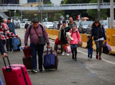 Ukrainians who fled to Mexico amid Russia's invasion of their homeland, walk with their belongings to cross the San Ysidro Land Port of Entry of the U.S.-Mexico border, in Tijuana, Mexico April 2, 2022. REUTERS/Jorge Duenes/File Photo