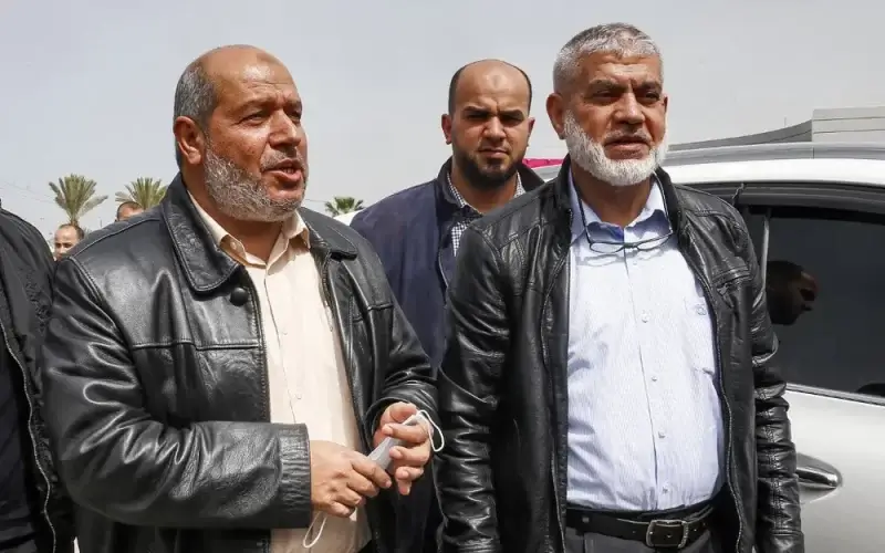 (Front L to R) Hamas ranking members Khalil Al-Hayya and Rawhi Mushtaha stand outside the VIP hall at the Rafah border crossing with Egypt in the southern Gaza Strip on March 15, 2021. AFP Photo / Said Khatib