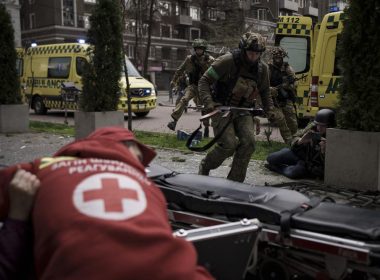 Ukrainian servicemen run for cover as explosions are heard during a Russian attack in downtown Kharkiv, Ukraine, Sunday, April 17, 2022. (AP Photo/Felipe Dana)