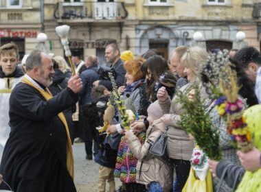 A Christian Orthodox priest blesses Ukrainians who hold pussy-willow branches as they celebrate Orthodox Palm Sunday in Lviv, Ukraine. Photo by Mykola Tys/EPA-EFE
