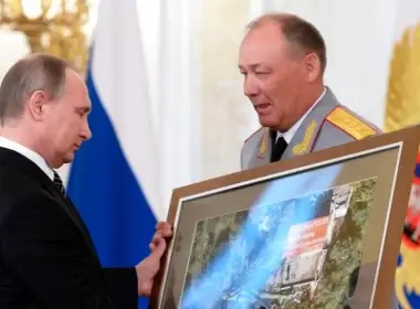 Russian President Vladimir Putin, left, receives a picture taken in Syria from Gen. Alexander Dvornikov during an award ceremony at the Kremlin, in Moscow, Russia, March 17, 2016.