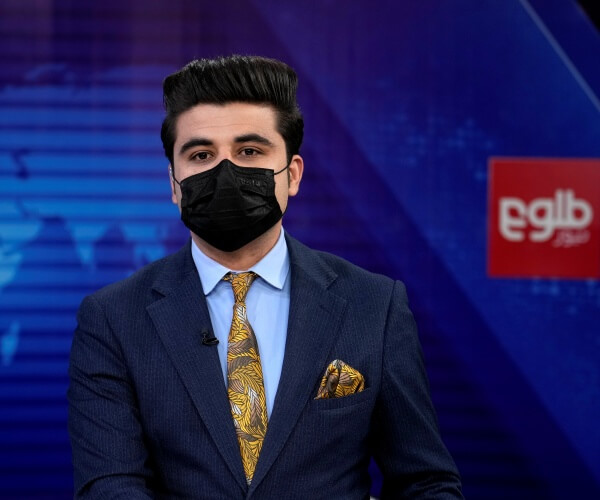 TV anchor Nesar Nabil wears a face mask to protest the Taliban's new order that female presenters cover their faces, as he reads the news on TOLOnews, in Kabul, Afghanistan, Sunday, May 22, 2022. (AP Photo/Ebrahim Noroozi)