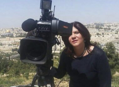 In this undated photo provided by Al Jazeera Media Network, Shireen Abu Akleh, a journalist for Al Jazeera network, stands next to a TV camera with the Old City of Jerusalem in the background. (Al Jazeera Media Network via AP)