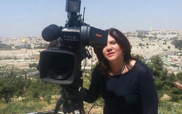 In this undated photo provided by Al Jazeera Media Network, Shireen Abu Akleh, a journalist for Al Jazeera network, stands next to a TV camera with the Old City of Jerusalem in the background. (Al Jazeera Media Network via AP)