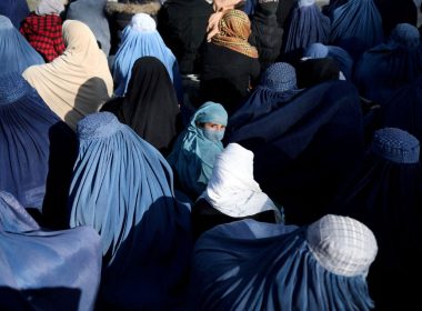 A girl sits in front of a bakery in the crowd with Afghan women waiting to receive bread in Kabul, Afghanistan, January 31, 2022. REUTERS/Ali Khara