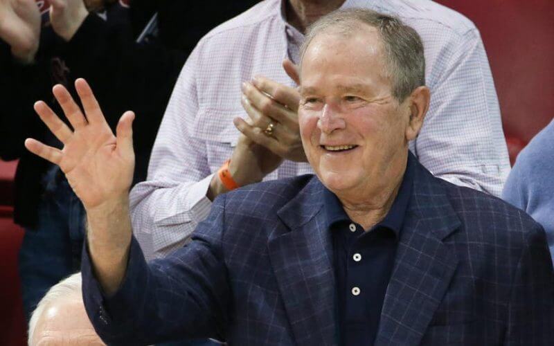 Former President George W. Bush waves to the crowd during a game between SMU and Cincinnati on March 3, 2022. GEORGE WALKER/ICON SPORTSWIRE VIA GETTY IMAGES