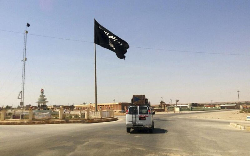 A motorist passes by a flag of the Islamic State group in central Rawah, 175 miles (281 kilometers) northwest of Baghdad, Iraq, July 22, 2014. Members of the global coalition fighting the Islamic State group are meeting in Morocco on Wednesday May 11, 20222 to discuss ongoing efforts in the campaign. The meeting is a reminder of the persistent threat from the extremist group despite the overwhelming preoccupation with Russia’s war on Ukraine. (AP Photo, File)