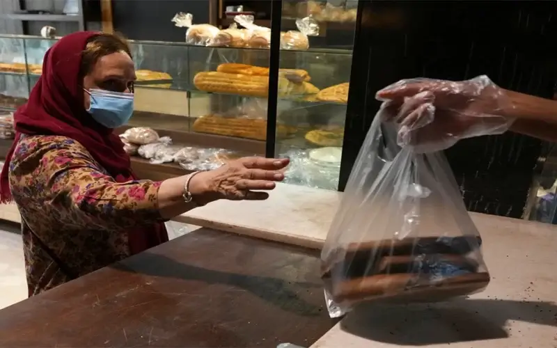 A customer buys bread in a bakery in Tehran, Iran, Wednesday, May 11, 2022. (AP Photo/Vahid Salemi)