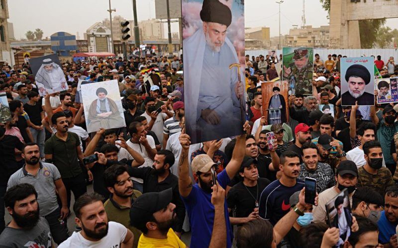 Followers of Shiite cleric Muqtada al-Sadr hold posters with his photo as they celebrate the passing of a law criminalizing the normalization of ties with Israel, in Tahrir Square, Baghdad, Iraq, Thursday, May 26, 2022. (AP Photo/Hadi Mizban)