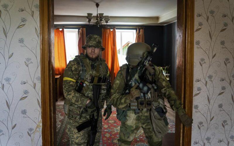 Ukrainian servicemen inspect a house during a reconnaissance mission in a recently retaken village on the outskirts of Kharkiv, east Ukraine, Saturday, May 14, 2022. (AP Photo/Mstyslav Chernov)
