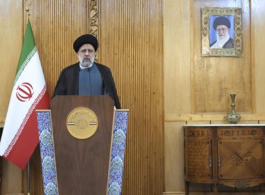 Iranian President Ebrahim Raisi speaks prior to departing Tehran's Mehrabad airport for a trip to Oman, Monday, May, 23, 2022. A portrait of the Supreme Leader Ayatollah Ali Khamenei hangs on the wall. (AP Photo/Vahid Salemi)